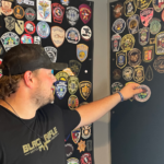 Black Rifle team member add service patches to the wall